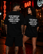 I’M NOT FAMOUS BUT I’M PRETTY SURE SOMEONE’S THERAPIST KNOWS MY NAME – schwarzes Oversize Unisex Shirt, weißer Backprint, Funny Shirt, Sarkasmus Geschenk